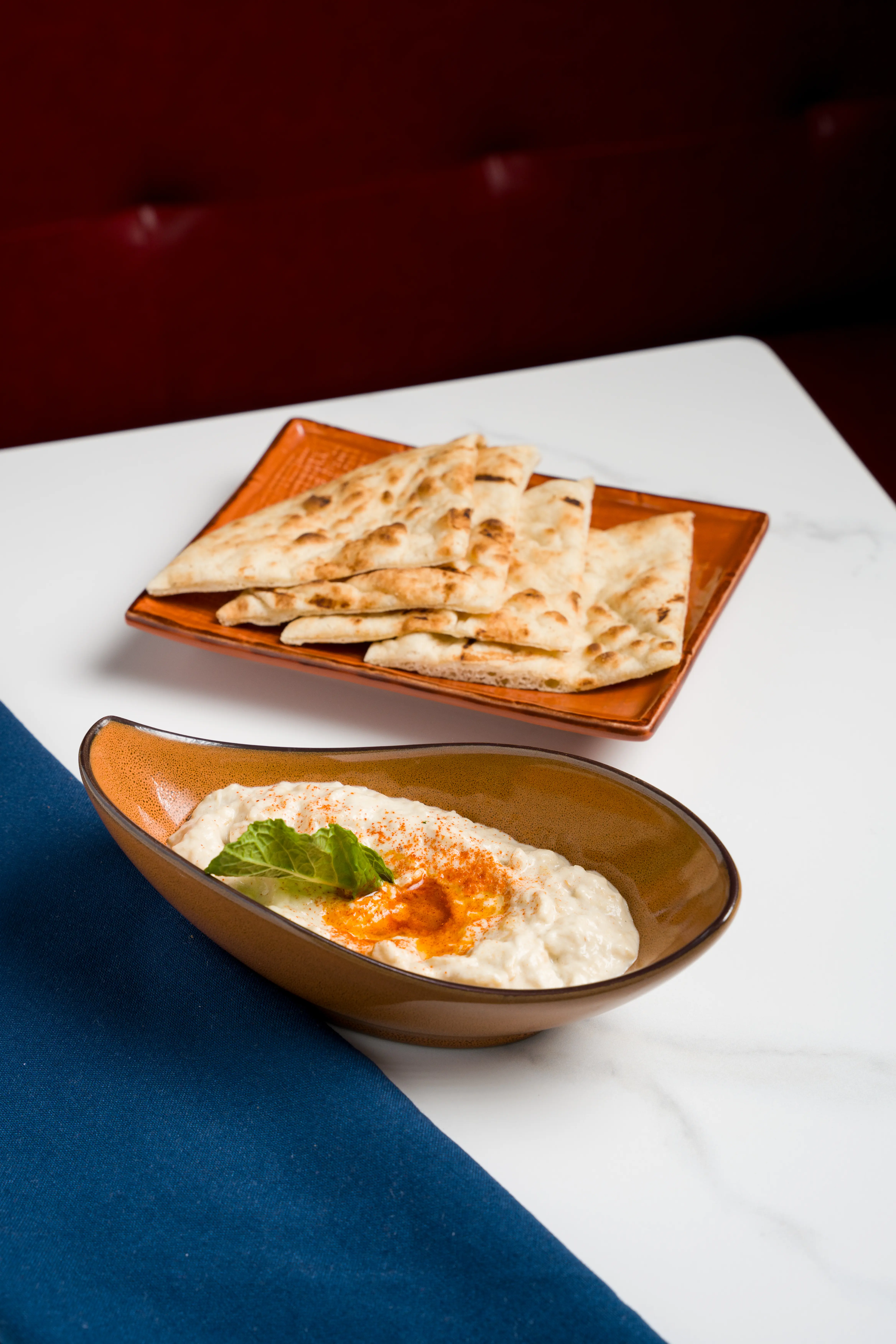 Creamy hummus with paprika oil and pita